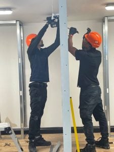 Two builders in helmets working